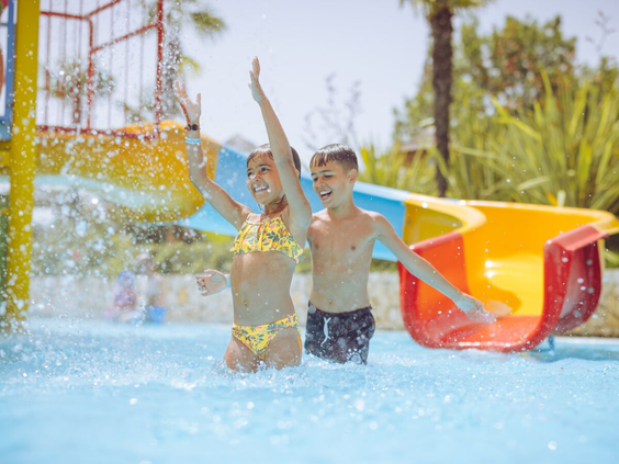 Kinderen hebben waterpret in het zwembad van camping Bella Italia.