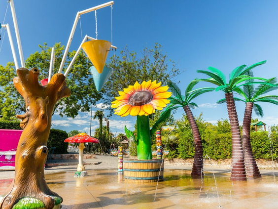 Kinderen spelen in het kleurrijke spraypark met waterfonteinen en speeltoestellen op camping Bella Italia.