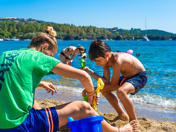 Spelen met zand op het strand bij Camping Capo d'Orso