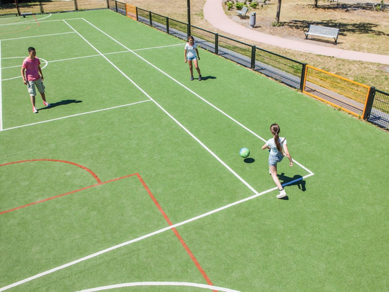 Kinderen spelen een potje voetbal op het multifunctionele sportveld van Camping de Schatberg.