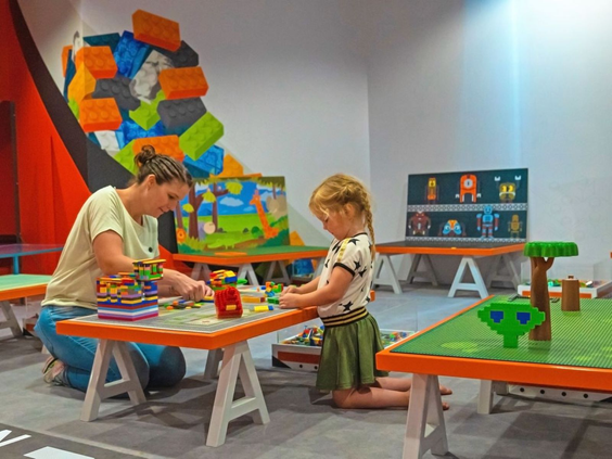 Kinderen zijn creatief aan het knutselen met grote blokken in de overdekte kidsclub van Camping de Schatberg.