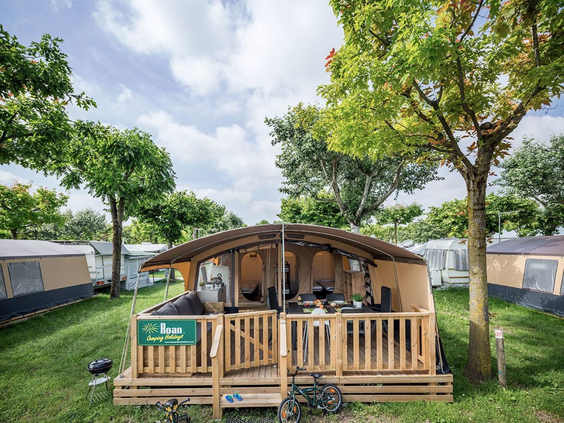 Luxe en ruime glamping safaritent met houten veranda op een kampeerplaats van Camping de Schatberg.