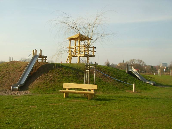 Grote speeltuin op een grasheuvel met een houten uitkijktoren en twee lange glijbanen op Knaus Campingpark Eschwege.