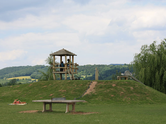 Het grote, natuurlijke speelparadijs van Knaus Campingpark Eschwege met diverse houten klimtoestellen en een tafeltennistafel.