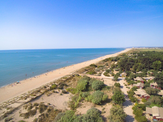 Luchtfoto van het brede zandstrand en de Middellandse Zee, direct gelegen bij Camping Le Sérignan Plage in Frankrijk.