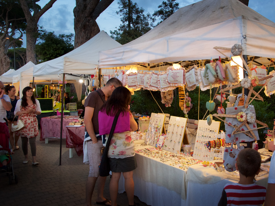 Gasten struinen 's avonds langs kraampjes met handgemaakte sieraden en souvenirs op de gezellige avondmarkt van camping Park Albatros.