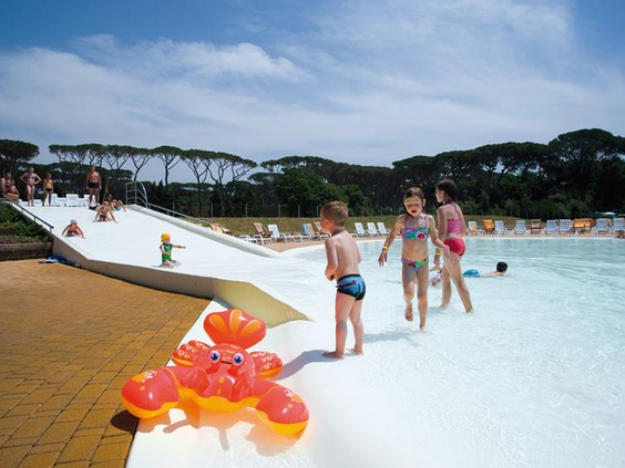 Kinderen spelen op de zachte, veilige bodem van het lagune zwembad op de kindvriendelijke camping Park Albatros in Toscane, Italië.
