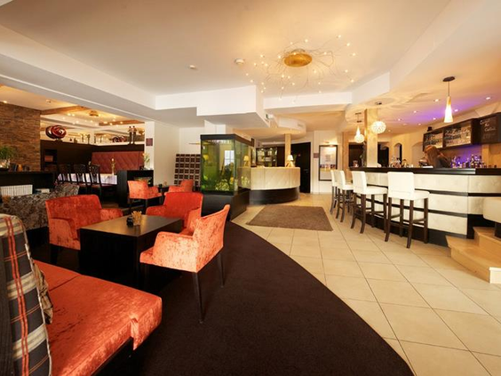 Ruimte met verschillende zithoeken en een bar in een hotel