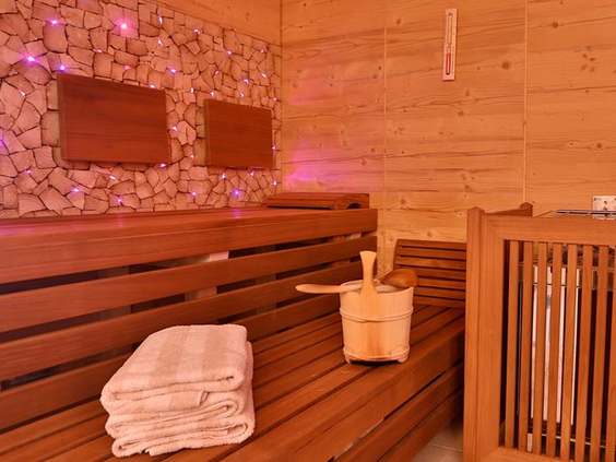 Sauna met paarse verlichting en handdoeken
