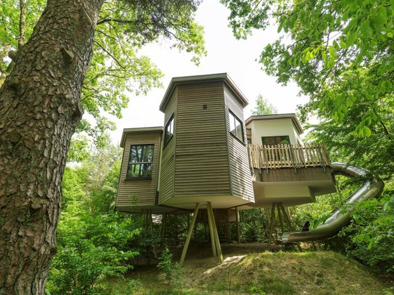 Een uniek Avontuur Boomhuis op hoge palen in het bos van Center Parcs Bispinger Heide, met een eigen glijbaan naar beneden.