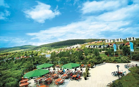 Panoramisch uitzicht over het heuvelachtige vakantiepark Center Parcs Park Hochsauerland vanaf het grote buitenterras.