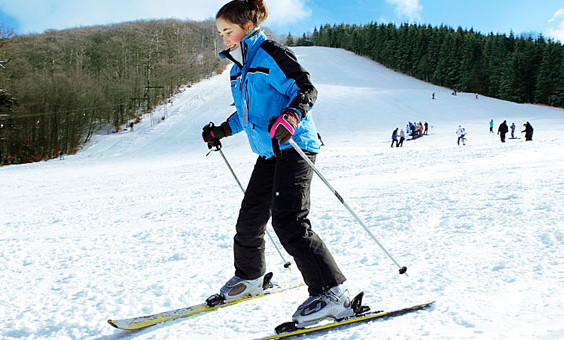 Meisje skiet van een besneeuwde piste in het skigebied van Winterberg, vlak bij Center Parcs Park Hochsauerland.