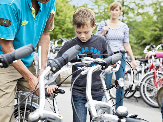 Een jongen krijgt een huurfiets aangemeten bij het Cycle Center van Park Hochsauerland om de omgeving te verkennen.