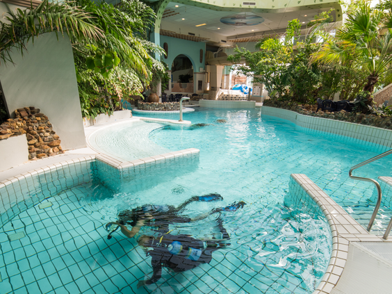 Kinderen met duikbrillen en snorkels kijken naar tropische vissen in het snorkelbad van de Aqua Mundo op Center Parcs Port Zélande.