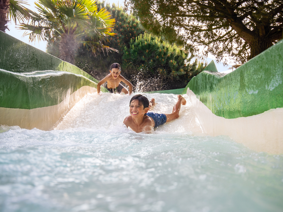Twee jongens glijden met hoge snelheid en veel plezier naar beneden in de wildwaterbaan van de Aqua Mundo op Center Parcs Port Zélande.