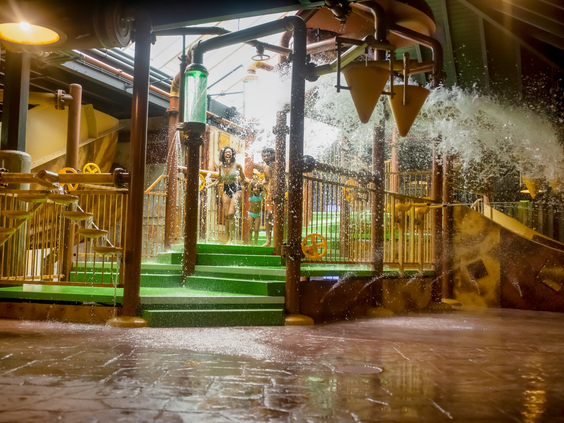 Kinderen spelen onder grote omkiepende emmers met water in het Water Playhouse van de Aqua Mundo bij Center Parcs Erperheide.