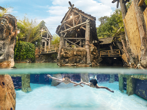 Twee mensen snorkelen onder water en kijken naar tropische vissen in het Aziatisch Vissersdorp in de Aqua Mundo van Center Parcs Erperheide.