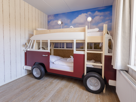 Een uniek stapelbed in de vorm van een rood Volkswagen busje in de kinderslaapkamer van een cottage op Center Parcs Zandvoort.