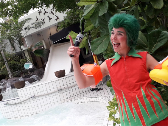 Een enthousiaste entertainer verkleed als het personage Orry staat met een microfoon bij de wildwaterbaan van de Aqua Mundo op Center Parcs Zandvoort.