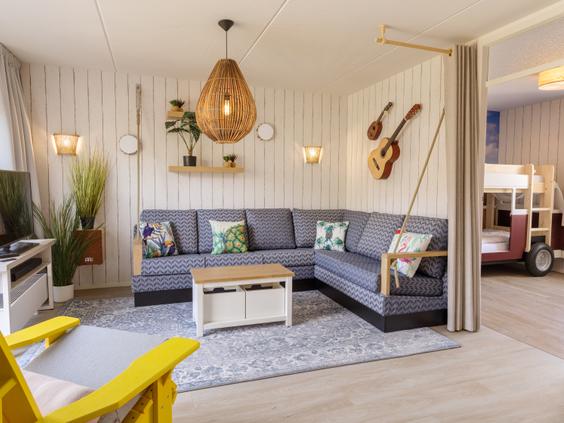 De sfeervolle en moderne zithoek met een comfortabele hoekbank en stranddetails in een van de vernieuwde cottages op Center Parcs Zandvoort.