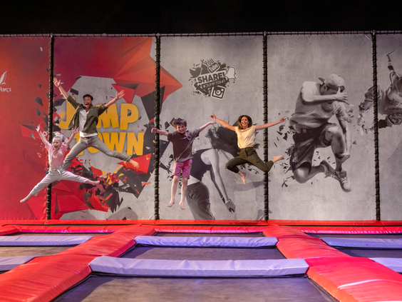 Een groep kinderen springt hoog in de lucht op de trampolines in de Jump XL Jump Town hal van Center Parcs Zandvoort.