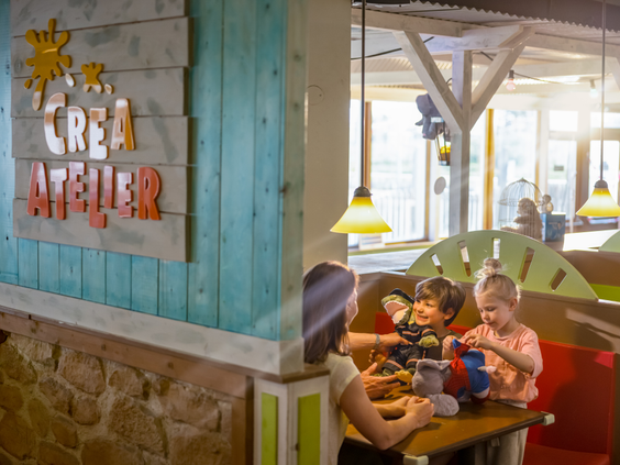 Kinderen zijn creatief bezig en maken hun eigen knuffel aan een tafel in het Crea Atelier van Center Parcs Zandvoort.
