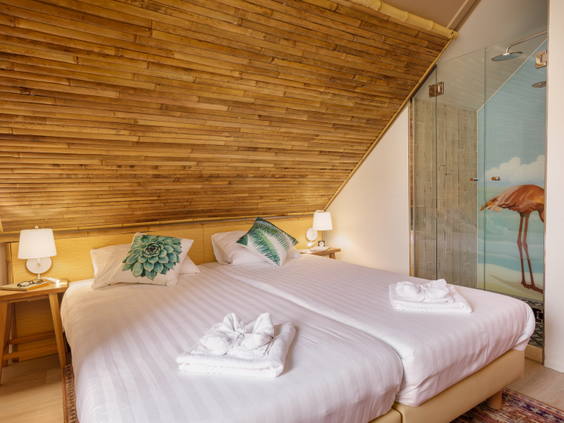 Een sfeervol ingerichte slaapkamer met een opgemaakt tweepersoonsbed in een van de vernieuwde cottages van Center Parcs Zandvoort.