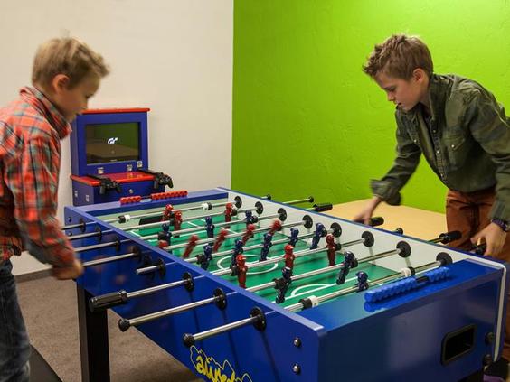 Twee kinderen spelen tafelvoetbal in een kinderspeelruimte