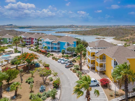 Luchtfoto van het kleurrijke CHOGOGO Dive & Beach Resort, met uitzicht op de zoutpannen van Jan Thiel baai op Curaçao.