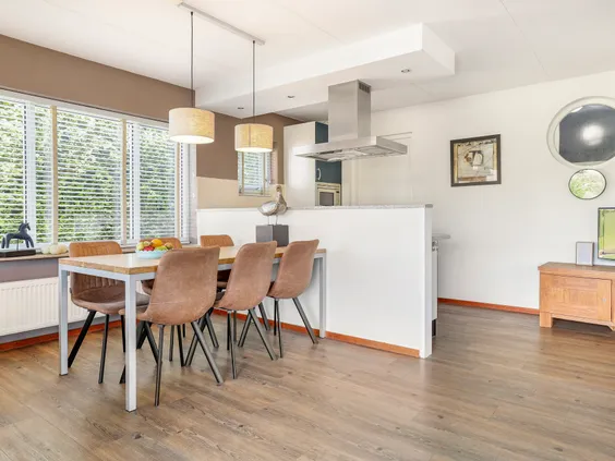 Lichte, open leefruimte met een moderne eethoek en uitzicht op de keuken in een vakantiehuis op de Bloemert.