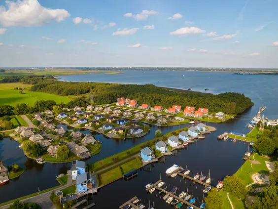 Hoge luchtfoto die Villapark de Bloemert en de jachthaven toont, gelegen aan de rand van het uitgestrekte Zuidlaardermeer.