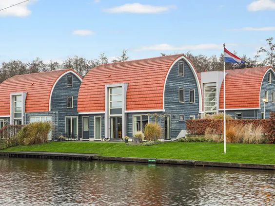 Moderne waterwoningen met opvallende ronde, rode daken direct aan het water gelegen op Villapark de Bloemert.