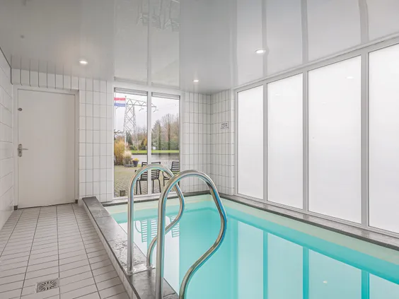 Luxe binnenzwembad in een wellness vakantiehuis op Villapark de Bloemert voor een privé duik.