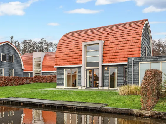 Een vakantiewoning met een terras en tuin direct gelegen aan het water op Villapark de Bloemert in Drenthe.