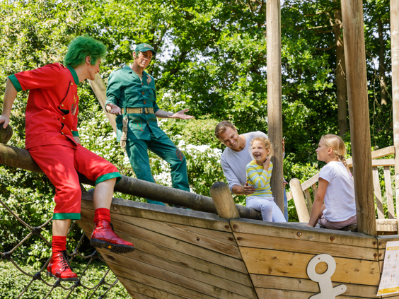 Entertainmentkarakters Orry en zijn vriend spelen met een vader en zijn twee dochters op een houten speelschip in een speeltuin van Center Parcs De Eemhof.
