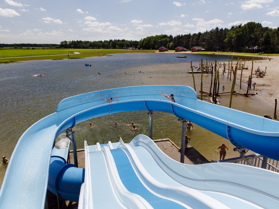 De grote blauw-witte familieglijbaan die uitkomt in recreatieplas 't Witven op Molecaten Park De Flaasbloem.