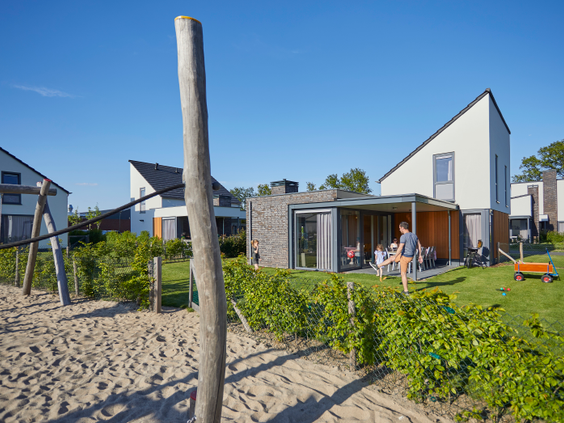 Moderne vakantiehuizen op Recreatiepark De Leistert met een centrale zandspeeltuin direct voor de terrassen.