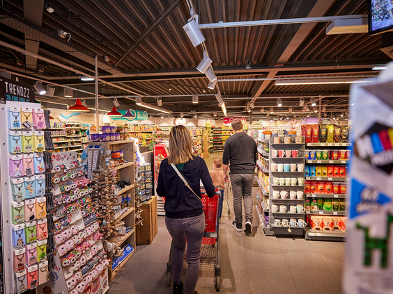 Een gezin met een volle winkelwagen doet boodschappen in de goed gesorteerde parksupermarkt van De Leistert.