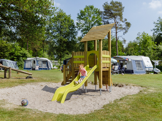 Een leuke speeltuin met een glijbaan, gelegen op een van de kampeervelden van RCN de Roggeberg, dicht bij de caravans.