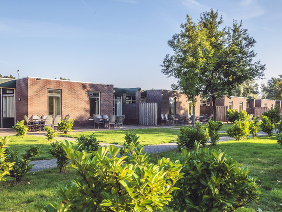 De moderne vakantiehuizen met zonnige terrassen, gelegen in het groene landschap van Recreatiepark De Scherpenhof.