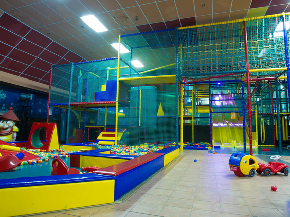 De kleurrijke indoor speeltuin Playcity op Recreatiepark De Scherpenhof met klimrekken, een ballenbak en zachte speelblokken.