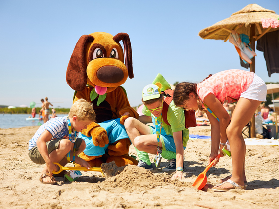 Mascotte Alex Avontuur bouwt samen met kinderen zandkastelen op het zandstrand aan het Veerse Meer bij RCN de Schotsman.