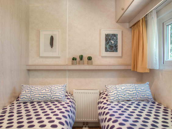 Gezellige kinderslaapkamer met twee losse bedden en een plankje met decoratie in een vakantieverblijf op De Wielerbaan.