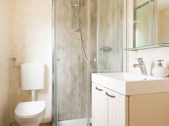 Lichte en moderne badkamer in een chalet op De Wielerbaan, met een inloopdouche, wastafel en toilet.