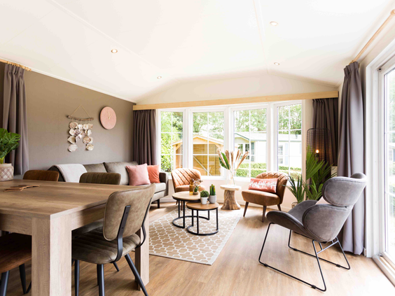 Stijlvol ingerichte woonkamer van een chalet op De Wielerbaan met een ruime zithoek, eettafel en grote ramen.