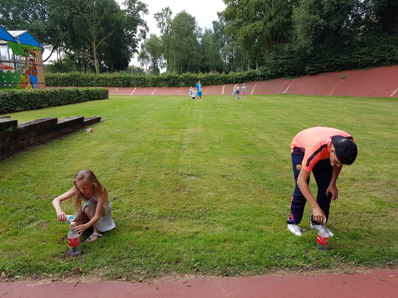 Twee kinderen spelen op de grasmat in het midden van de oude wielerbaan op het vakantiepark in Wageningen.