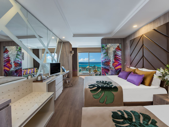 Stijlvolle hotelkamer met een tweepersoonsbed, moderne inrichting en uitzicht op zee bij Delphin BE GRAND Resort.