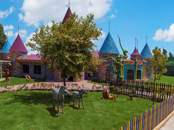 De buitenkant van de kidsclub van Delphin BE GRAND Resort, vormgegeven als een kleurrijk sprookjeskasteel.