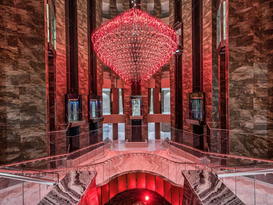 De indrukwekkende lobby van Delphin BE GRAND Resort met een gigantische rode kristallen kroonluchter.
