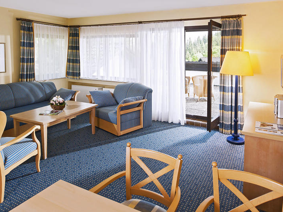 De ruime woonkamer van een vakantiehuis op Dorint Vakantiepark Daun met een comfortabele zithoek, eethoek en toegang tot het terras.